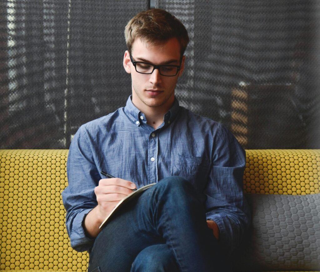 A young man in glasses writes an article on travel with Mughal